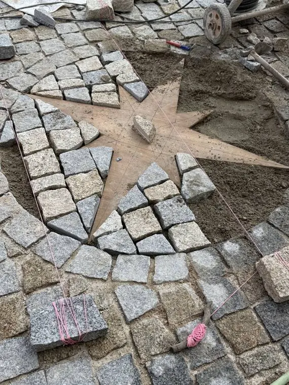 Rosace en pavés de granit en cours de pose dans une allée privée