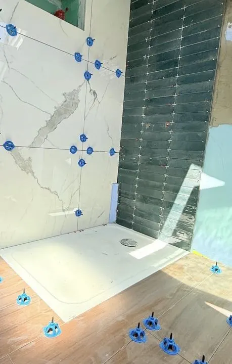 Pose de carrelage dans une salle de bain : grand format effet marbre et carrelage vert